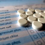 Integratori di magnesio su un tavolo, con un orologio che segna l'ora, evidenziando l'importanza del momento di assunzione.