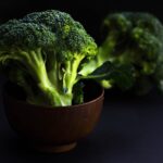 Broccoli freschi su un tavolo, illustrando i benefici e i rischi del loro consumo.