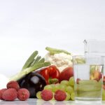 Un bicchiere d'acqua posizionato accanto a un piatto durante un pasto.