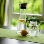 Un bicchiere d'acqua accanto a un piatto durante un pasto, simbolo di idratazione e digestione.