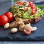 Avocado toast con ingredienti freschi, ideale per ridurre il colesterolo alto.