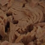 Scatola di tonno di marca controversa, evidenziando la scarsa qualità del prodotto.